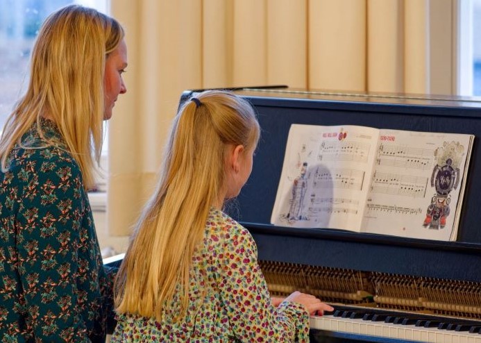 Mutter und Tochter am Klavier 